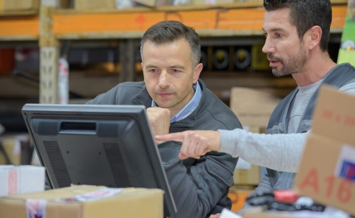 warehouse worker and manager using computer in a warehouse