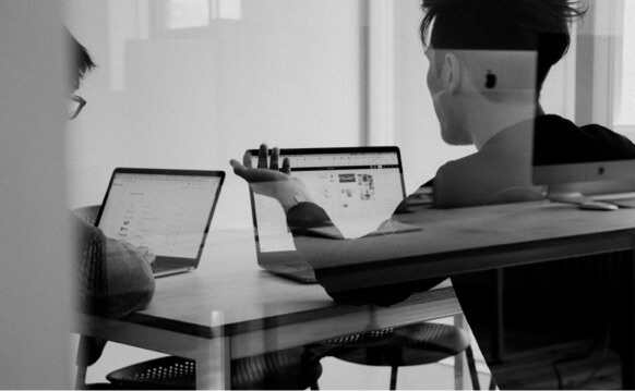 two people in a meeting looking at laptops